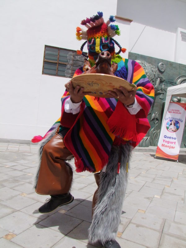 Gabriel García, con el traje de Diablo Huma, porta una cabeza de chancho hornado, afamado plato típico de Gualaceo.(AZD)