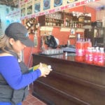 Una funcionaria de Arcsa, revisa las fechas de caducidad de los productos en un local de Paute. (Cortesía)