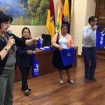 La coordinadora de Economía Comunitaria del GAD Provincial (D), María del Carmen Farfán y artesanos, muestran el modelo de las bolsas.(Cortesía)