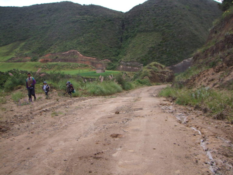 Pablo Astudillo y su familia camina en la carretera en rehabilitación, en el tramo de la comunidad Manzano.(AZD)