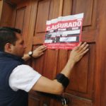 Un funcionario de la ACESS coloca el sello de clausura en el laboratorio que incumplió la normativa.(Cortesía)