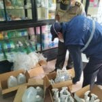 Funcionarios de Arcsa, durante el decomiso en una de las farmacias de Paute.(Cortesía)