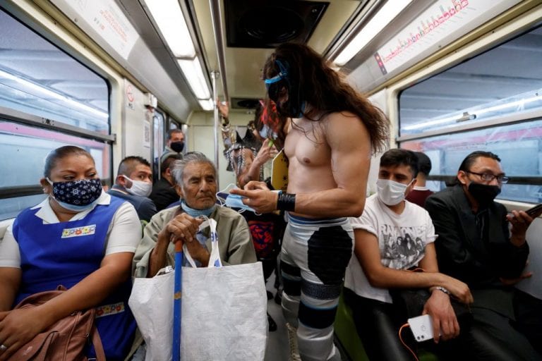 Mascarillas a la fuerza: luchadores mexicanos reparten cubrebocas en el metro