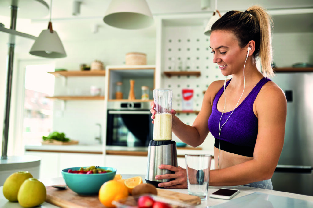 Young,Happy,Athletic,Woman,Making,Fruit,Smoothie,In,The,Kitchen. thumbnail