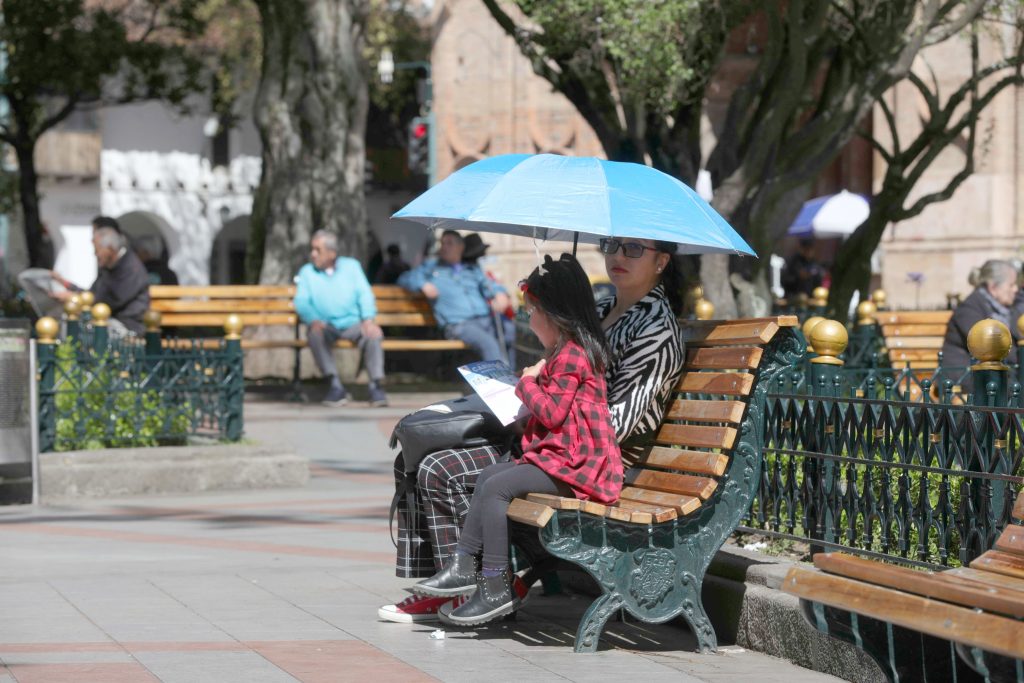 En el Centro Histórico de Cuenca, algunos ciudadanos utilizan sombrilla para protegerse del sol. /XCA