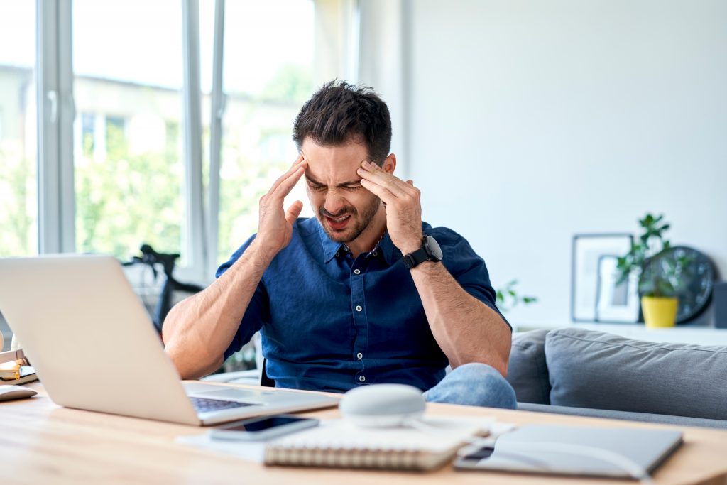 Young,Man,Suffering,Migraine,Pain,While,Working,At,Home thumbnail