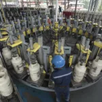 Trabajadores de la planta de Austrogas, en la Panamericana Norte, durante su trabajo cotidiano. /XCA