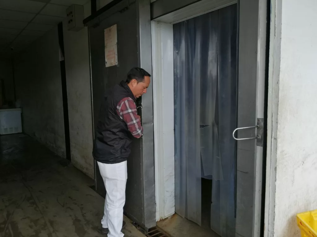 Peter Toalogo, administrador del mercado 12 de Abril, recorre la zona del cuarto de frío de cárnicos que, por ahora, no funciona. / FCS