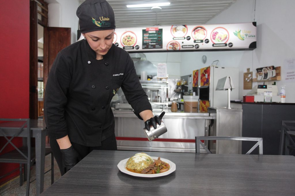 Gabriela Andrade, del local “Verde y Pintón”, prepara una de las delicias con plátano verde que ofrece a sus clientes. XCA
