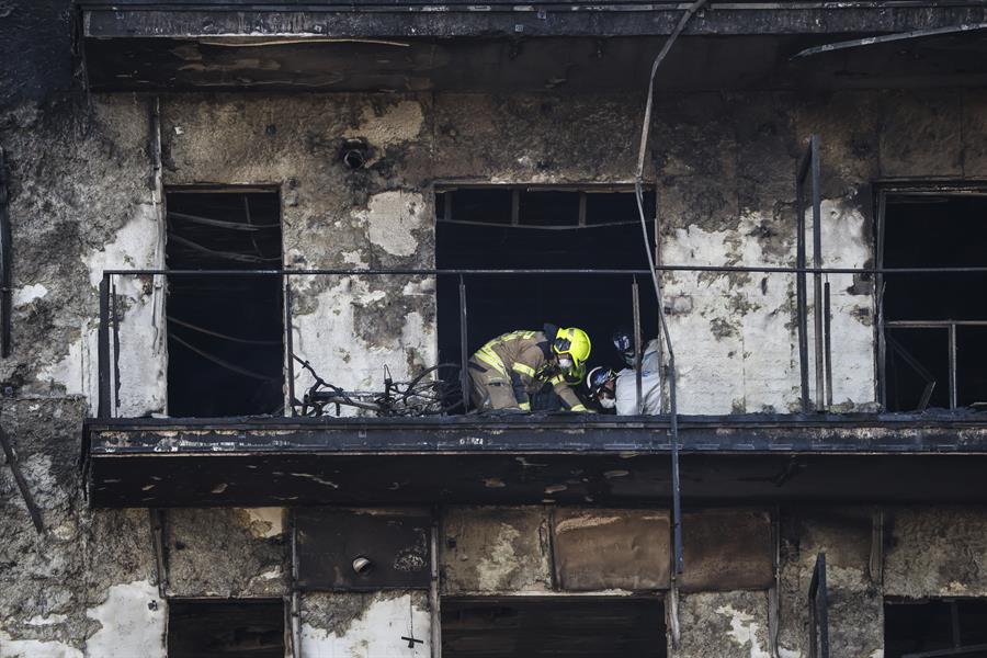 Bomberos y Policía Científica inspeccionan un cuerpo en un balcón del edificio incendiado en el barrio de Campanar de València. La cifra de víctimas mortales en el incendio se eleva a 10 tras la primera inspección ocular que han hecho en el interior de las instalaciones los bomberos y la Policía Científica. EFE