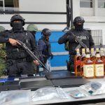 Personal policial custodiando los resultados obtenidos en el operativo ejecutado en el ario Cayambe.