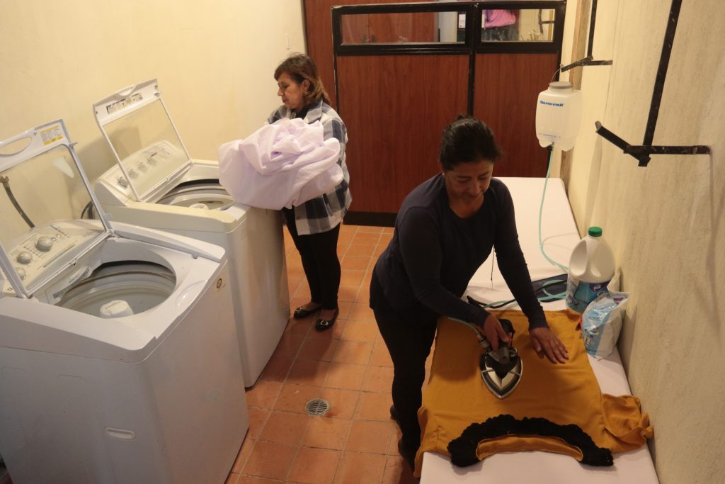 Janeth León y Digna Barros prueban las lavadoras y el área de planchado que se implementó en la Casa de la Mujer. XCA