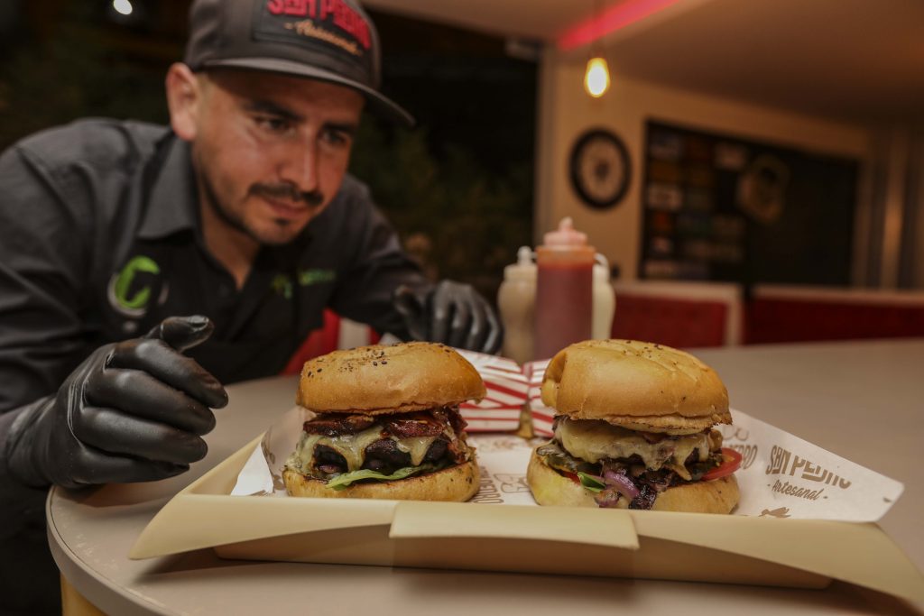 David Ordóñez, de “San Pedro Artesanal”, muestra dos de las hamburguesas que elaboran. La materia prima la obtienen de sus reses que tienen en corrales en Cuenca y Nabón. XCA