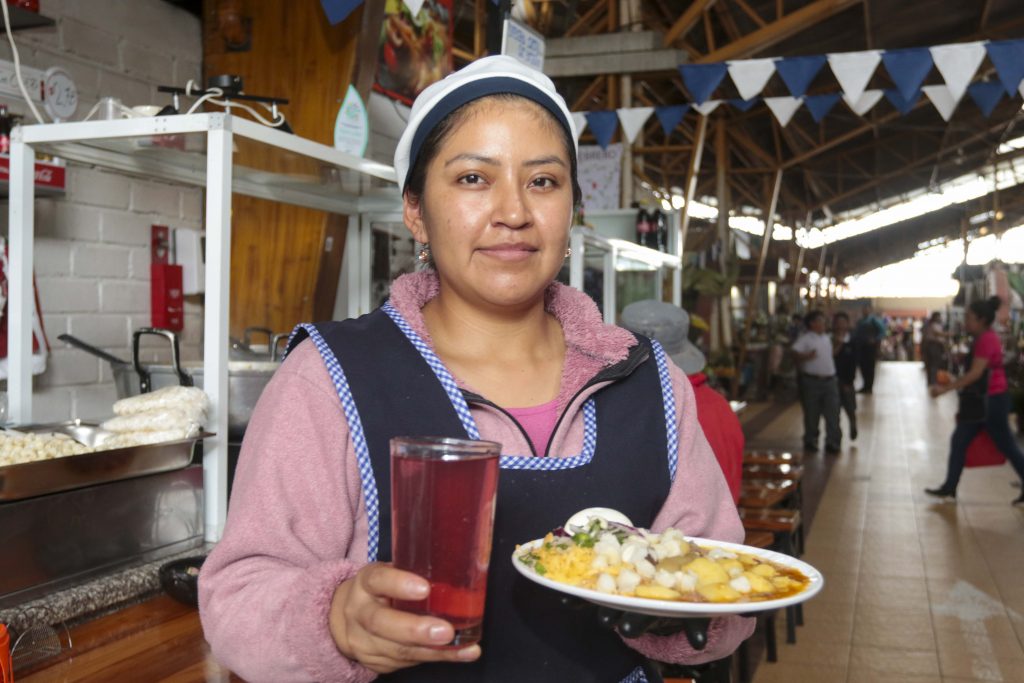 Nathaly Saquipay, del mercado “27 de Febrero”, muestra un plato de “papas locas”. La mujer trabaja junto a su esposo en el centro de abastos. XCA