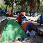 Migrantes descansan en un campamento improvisado este domingo, en una plaza del municipio de Tapachula, en el estado de Chiapas (México).EFE