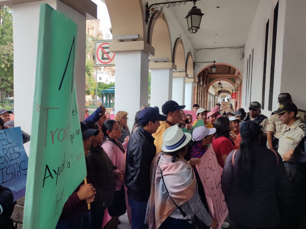 Transportistas reclaman por falta de pago frente a la Gobernación de Azuay.