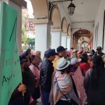 Transportistas reclaman por falta de pago frente a la Gobernación de Azuay.