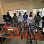 Militares presentan a detenidos con armas sobre una mesa.