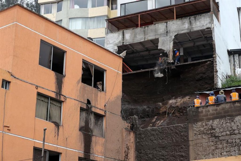 Obreros ayudan con la limpieza tras el aluvión ocurrido el martes, que dejó un fallecido en el barrio La Gasca, en Quito.