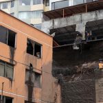 Obreros ayudan con la limpieza tras el aluvión ocurrido el martes, que dejó un fallecido en el barrio La Gasca, en Quito.