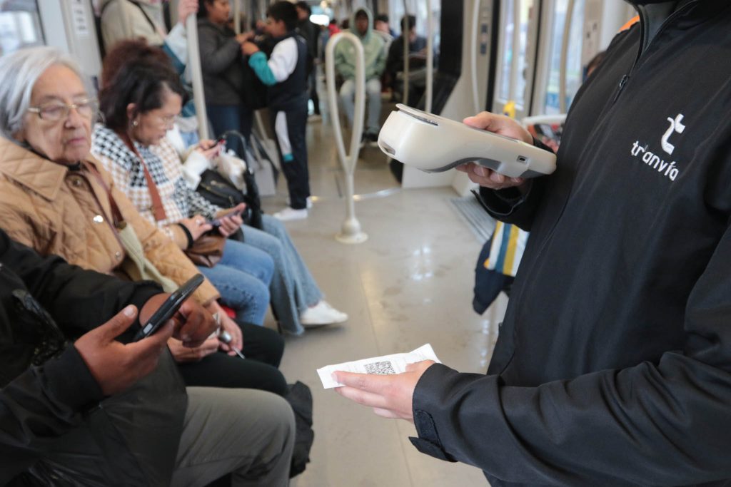 Controlador del Tranvía de Cuenca revisa si los usuarios han pagado su pasaje.
