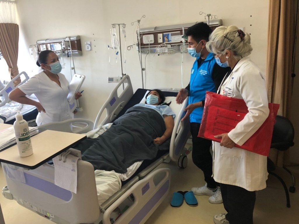 Personal médico del MSP visita a una paciente que está en una cama de hospital