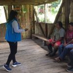 Una funcionaria del MIES dando información a una familia pobre.