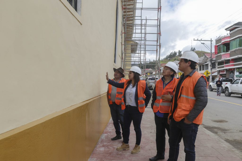 El equipo multidisciplinario de especialistas muestran el muro restaurado en la iglesia patrimonial de la parroquia Cumbe. XCA