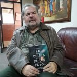 El autor Alex Chionetti junto con el nuevo libro que presentó en la Universidad de Cuenca. /FCS