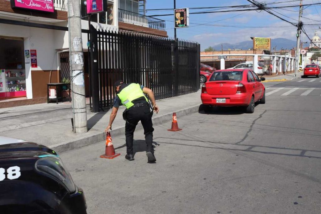 Agente de la EMOV EP retira conos en la vía pública. Hay sanción por colocar estos objetos.
