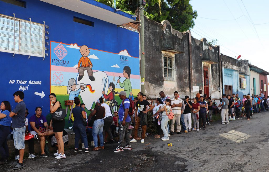 Migrantes hacen fila a la espera de resolver su situación migratoria el miércoles 7 de agosto de 2024. Foto EFE.
