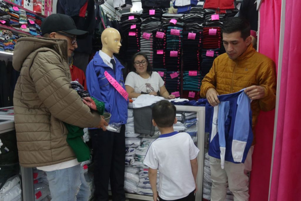 Un padre de familia compra los uniformes para su hijo en el local “Baby Mundo”, ubicado en la calle General Torres.