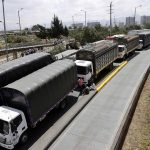 Centenares de camioneros y conductores de transporte público bloquean la autopista sur en Bogotá (Colombia), para protestar por el incremento en los precios de los combustibles, principalmente el diésel, que comenzó a regir el sábado pasado. EFE