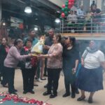 Rosa Matute, dirigente de la ‘Asociación Unión y Progreso’, recibe la imagen del Niño Viajero en su visita al Mercado 9 de Octubre.