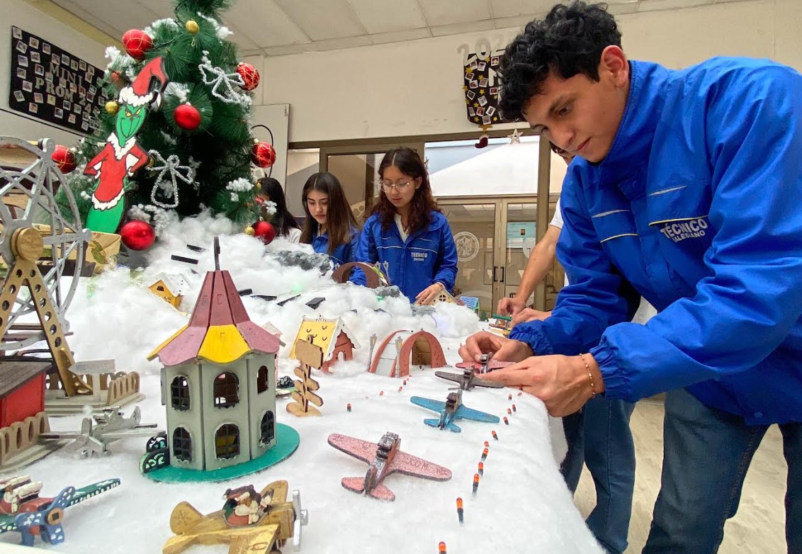 Estudiantes de la Unidad Educativa "Técnico Salesiano" decoran el espacio junto al árbol navideño, con elementos elaborados en los talleres del plantel