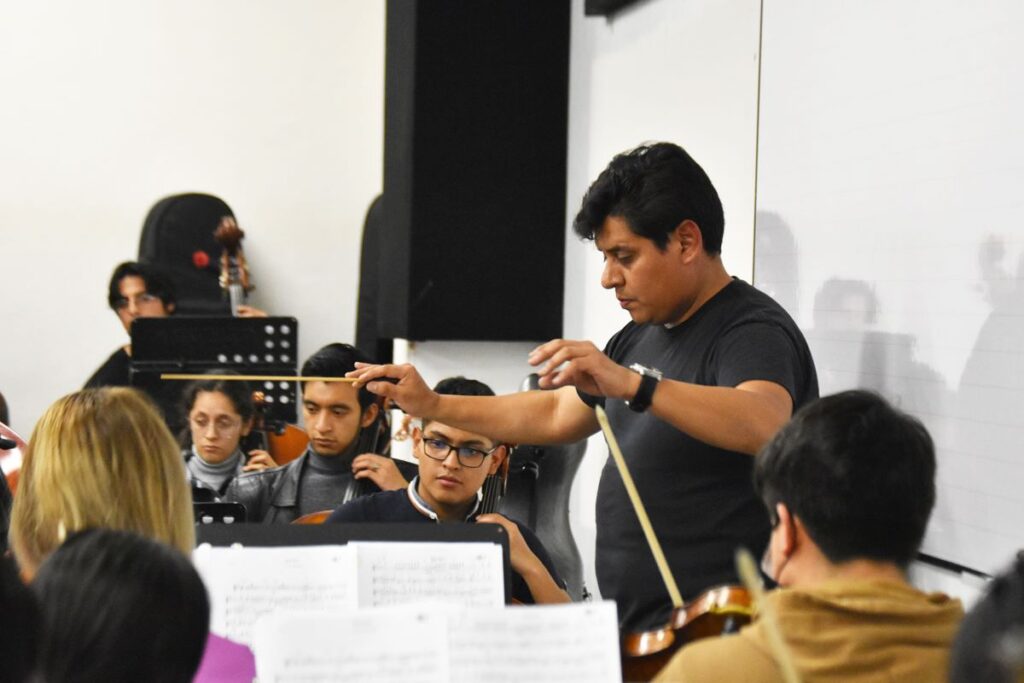 El maestro Marco Saula, dirige un ensayo de la Orquesta Sinfónica de la Universidad de Cuenca.