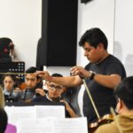El maestro Marco Saula, dirige un ensayo de la Orquesta Sinfónica de la Universidad de Cuenca.