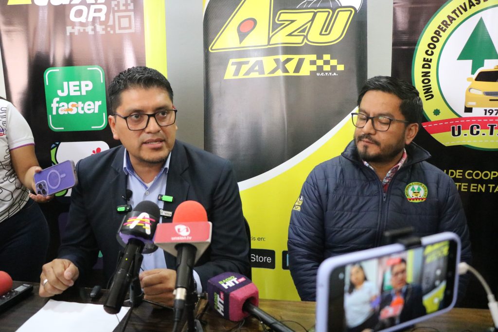 Eduardo Andrade y Henry López , representantes de la Unión de Taxis del Azuay durante rueda de prensa.