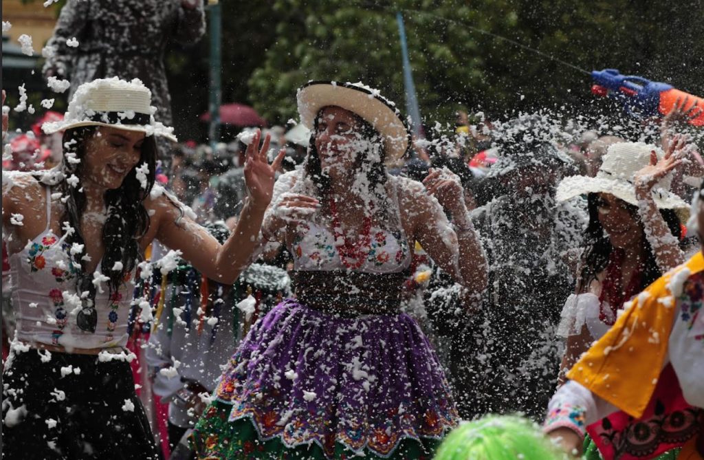 Un grupo de personas disfruta del "Desfile de Carnaval de los Cuatro Ríos de Cuenca".