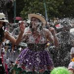 Un grupo de personas disfruta del "Desfile de Carnaval de los Cuatro Ríos de Cuenca".