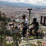 Dos visitantes en la bicicleta extrema, una de las atracciones del parque ‘Aventuri, Diversión Extrema’ en Turi.