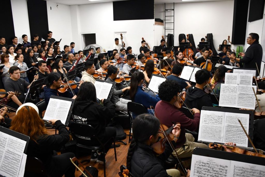 El maestro William Vergara (D) director de la Orquesta Sinfónica de la Universidad de Cuenca, durante un ensayo de la obra.