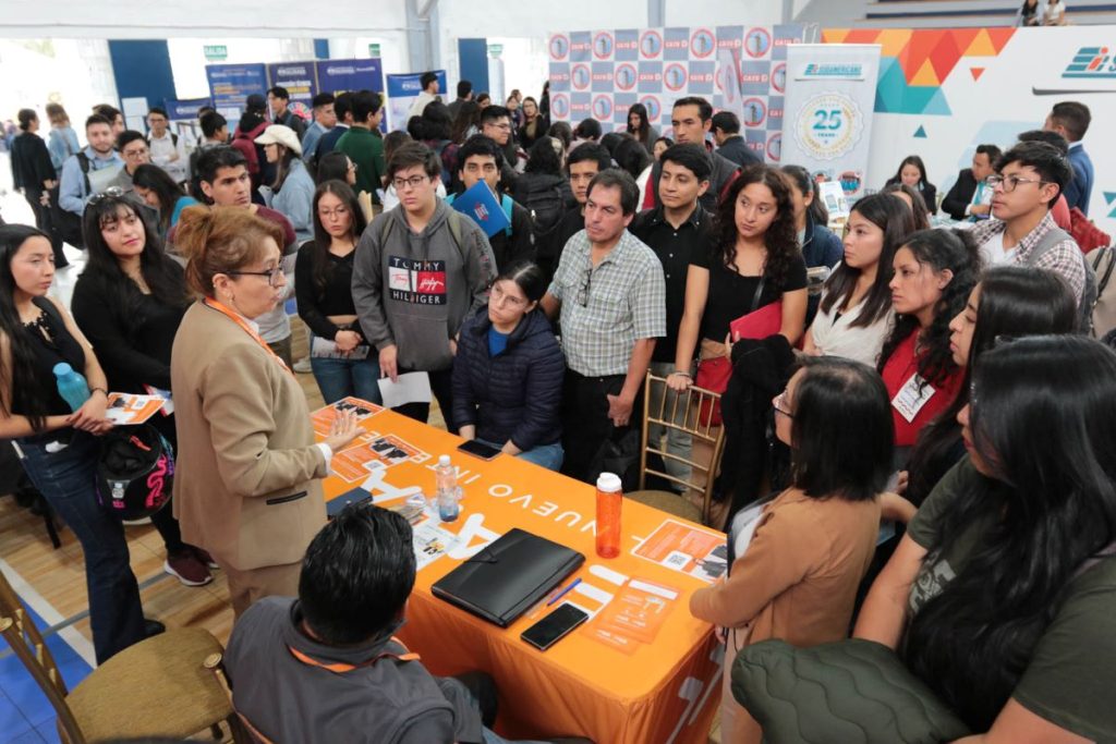 Un grupo de personas participa en Alumni Conecta 2025: Feria de Empleabilidad, Emprendimiento e Innovación, en el coliseo de la UPS.