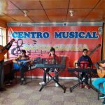 Rafael Auquilla, director del Centro Musical Santa Cecilia, junto a un grupo de alumnos.