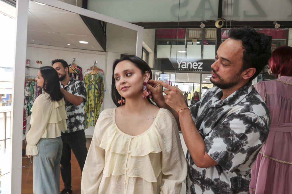 El diseñador David Ossandón coloca una joya a Amelia Ávila Zeas, en su local ubicado en el Centro Comercial El Vergel.