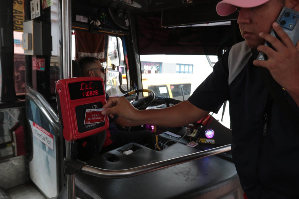 Usuario pasa su tarjeta Movilízate al subir a un bus de la Cámara de Transporte de Cuenca.