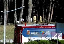 Personal de la Policía Nacional realiza el levantamiento del cadáver hallado en el río Cuenca con el apoyo del Cuerpo de Bomberos.