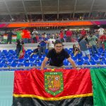 Martín Álvarez Estrella junto a la bandera del Deportivo Cuenca, en el partido entre Portugal vs Ghana.