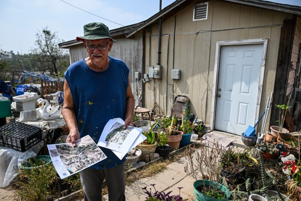 Antonio Rosales muestra una fotografía por donde pasará el muro. Foto: AFP