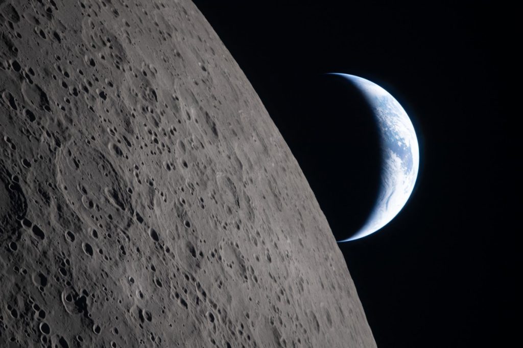 Vista de la superficie lunar y de la Tierra desde la nave Orion. Foto: AFP